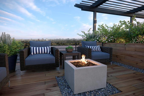 Small rooftop deck with a square gas fire pit, wicker lounge chairs, and lush planter garden overlooking the city skyline
