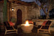 Night garden patio with lit gas burning fire pit and comfortable outdoor furniture